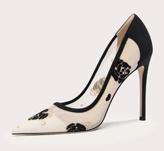 Black and white high-heeled shoe with floral design on a light gray background