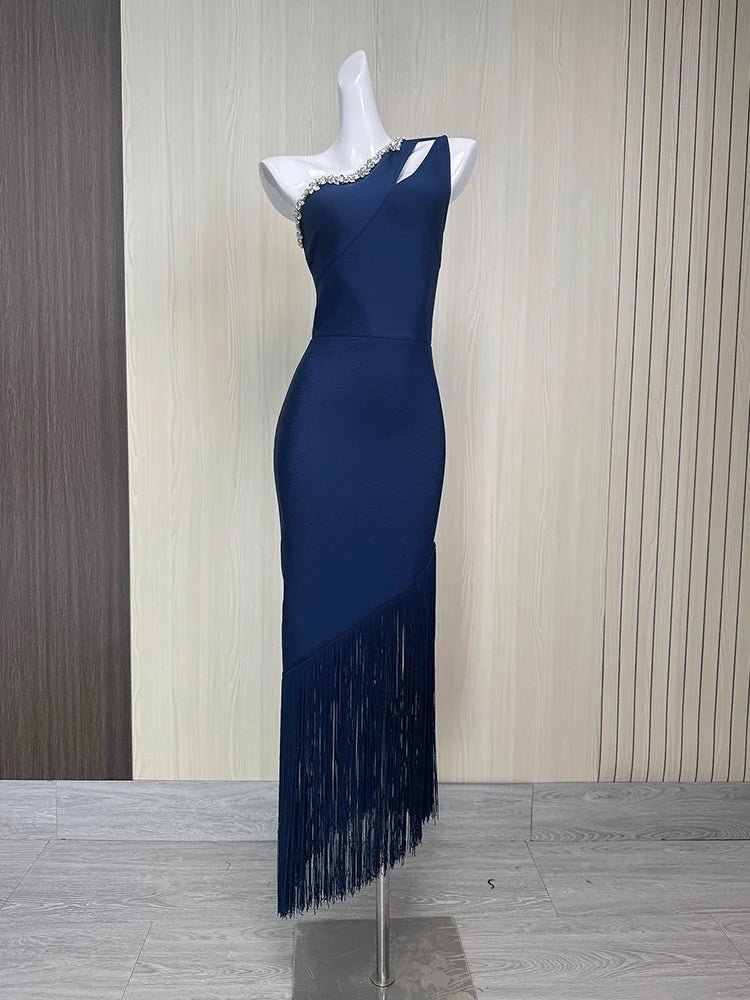 Navy blue dress with fringe on a mannequin against a striped wall.