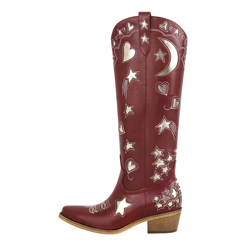 Side view of a red embroidered star and moon knee-high boot with a pointed toe and block heel.