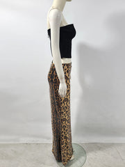 Mannequin wearing a black top and leopard print pants against a white background