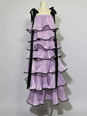 Purple dress with black ruffles on a mannequin against a white background