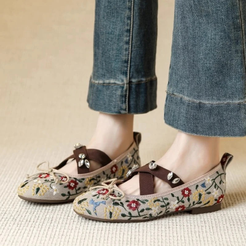 Embroidered floral print Mary Jane flats worn on feet with jeans