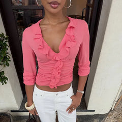 Close-up of the ruffle detail on a pink V-neck cropped top.