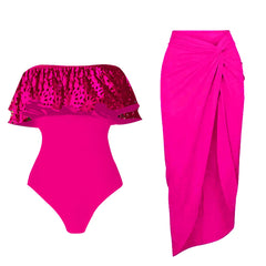 Bright pink strapless one-piece swimsuit with a ruffled top and a bright pink knotted wrap skirt.