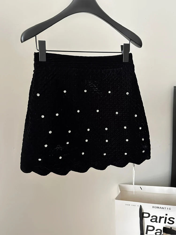 Black skirt with white polka dots on a hanger against a neutral background