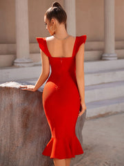 Woman in a red dress standing in an outdoor setting with columns.