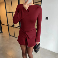 Person wearing a burgundy dress with long sleeves in an indoor setting.