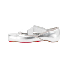 Silver ballet flats with a red sole on a white background