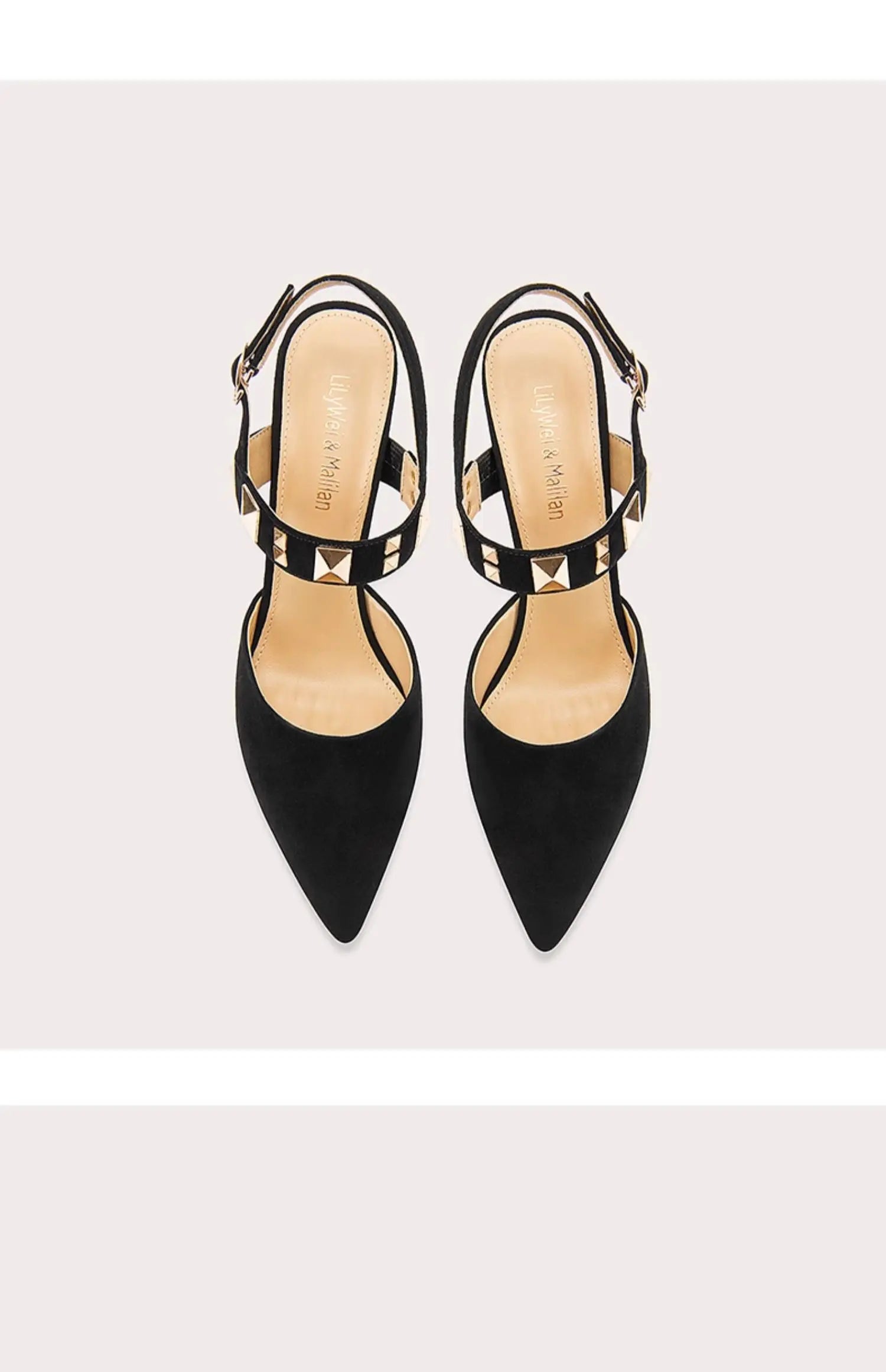 Pair of black high-heeled shoes with thin straps on a light gray background