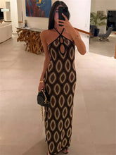Woman taking a mirror selfie wearing a patterned dress in an indoor setting.