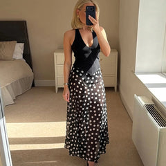 Close-up of the sheer polka dot fabric on a black maxi dress.