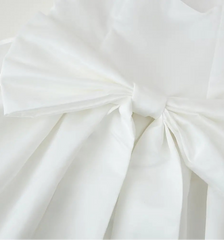 Close-up of a white fabric with a large bow on a light background