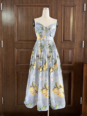 Dress with lemon pattern on a mannequin against a wooden door background