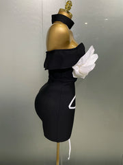Black off-shoulder dress with white gloves on a mannequin against a neutral background