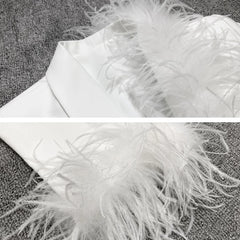 Close-up of a white feathered item on a textured surface