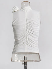 White pleated top on a mannequin against a white background