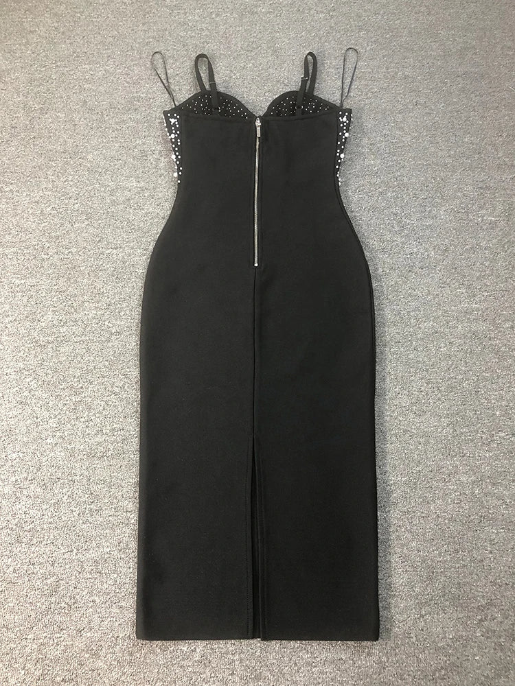 Black jumpsuit with embellished straps on a gray surface