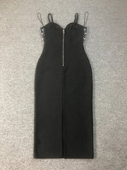 Black jumpsuit with embellished straps on a gray surface