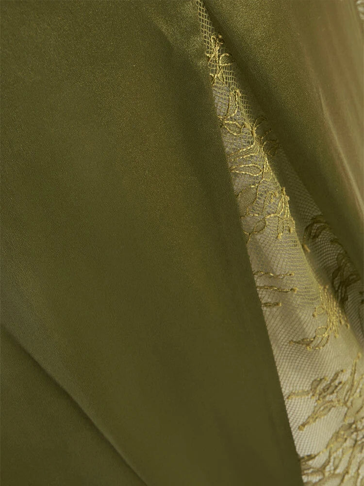 Close-up of olive green fabric with embroidered gold pattern