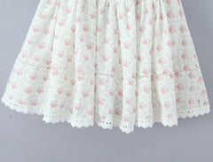 White lace skirt with pink floral pattern on a gray background