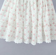 White lace skirt with pink floral pattern on a gray background