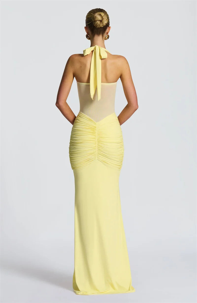 Woman wearing a yellow evening gown with a plain background