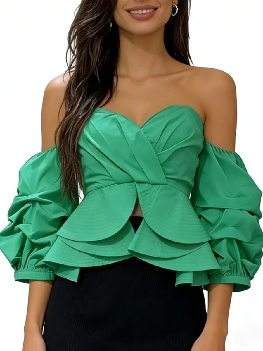 Green off-shoulder top with ruffled sleeves worn by a model on a white background