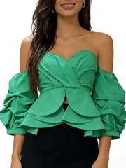 Green off-shoulder top with ruffled sleeves worn by a model on a white background