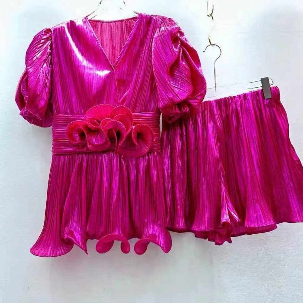 Shiny pink dress with floral details on a white background