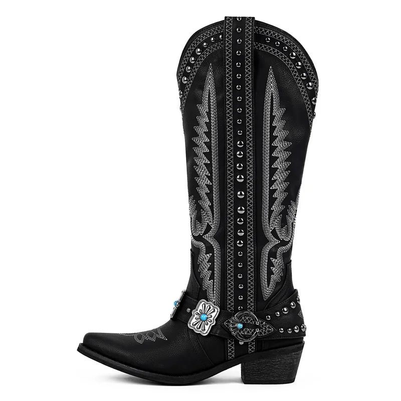 Black cowboy boot with intricate silver embroidery and a turquoise buckle on a white background