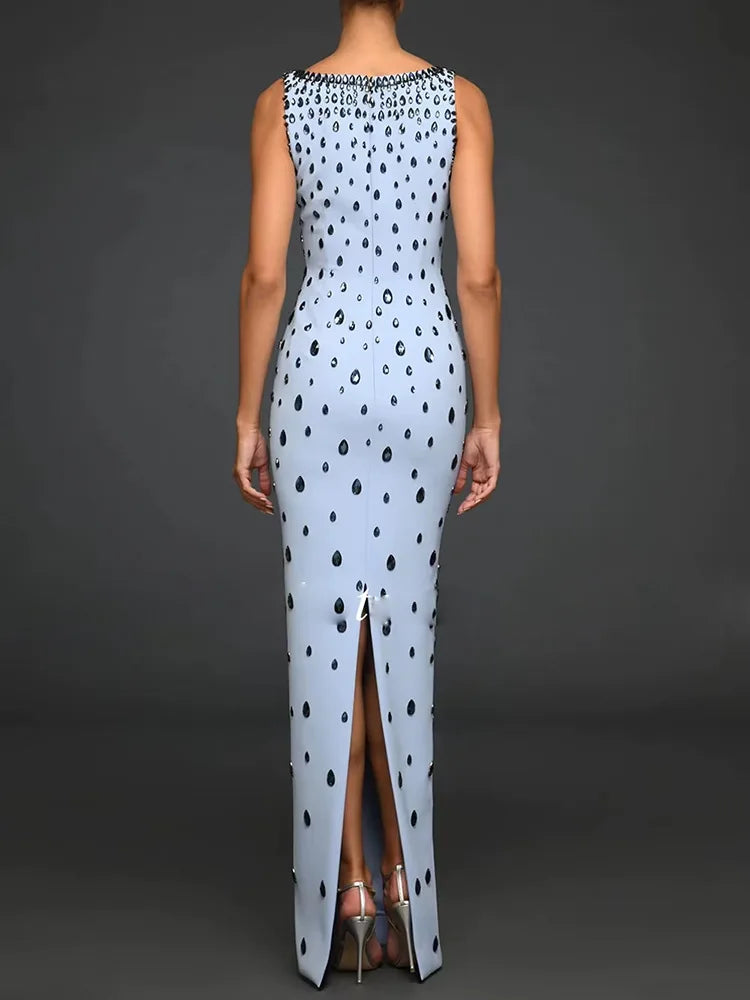 Woman wearing a polka dot dress with a high slit on a dark background