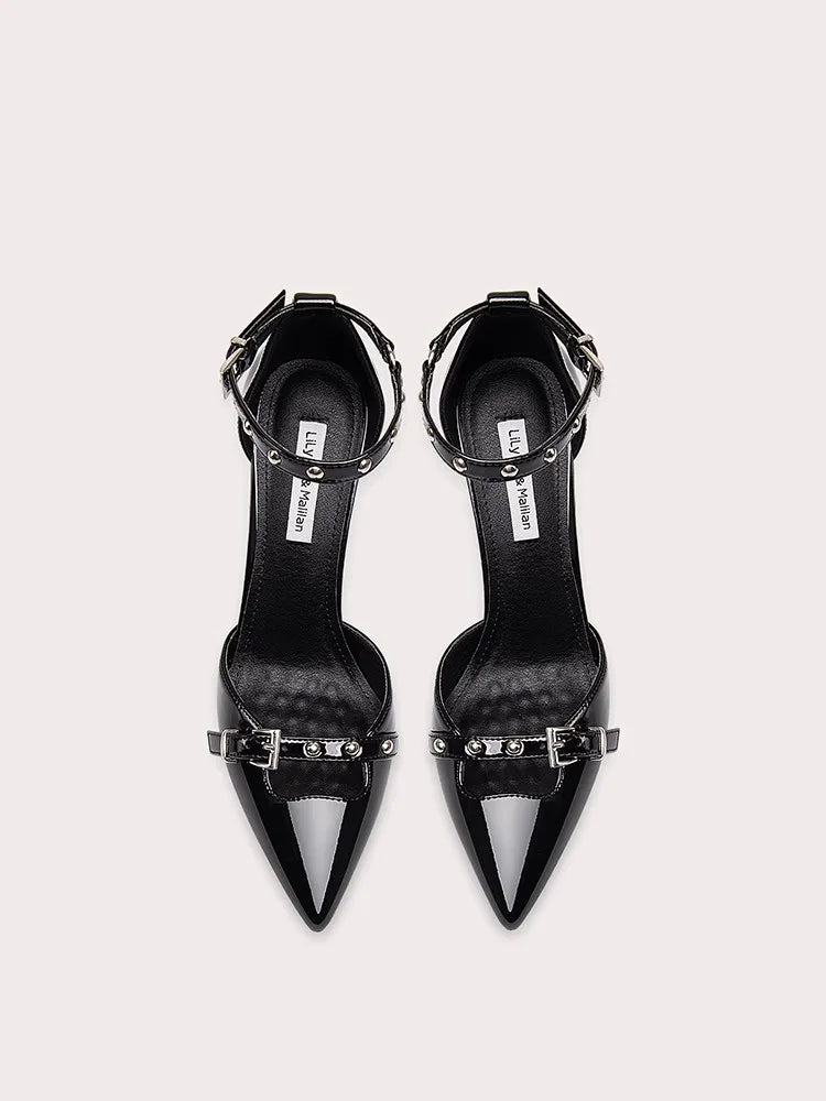 Pair of black high-heeled shoes with decorative straps on a white background