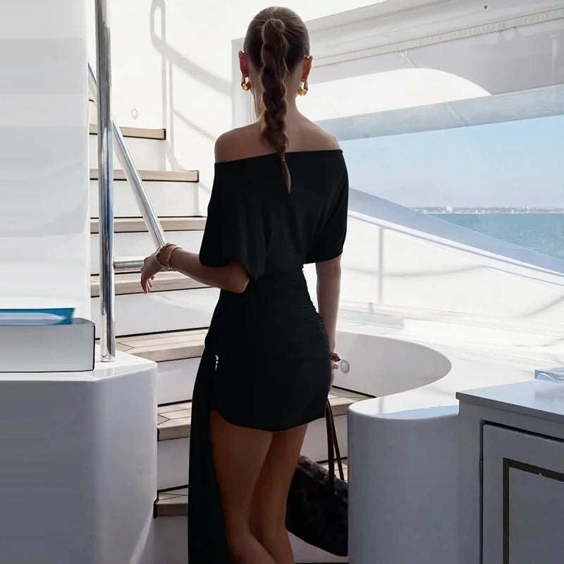 Woman in a black off-shoulder dress on a yacht deck with ocean view