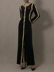 Black dress with gold trim and colorful beads on a gray background