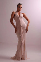 Woman wearing a beige evening gown against a plain background