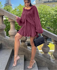 Woman in a burgundy dress standing on stone steps with the Eiffel Tower in the background