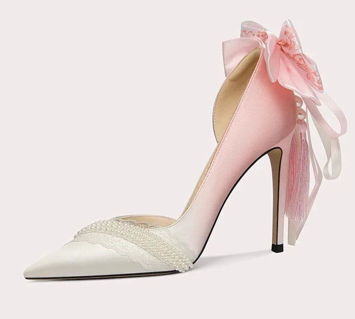 Pink high-heeled shoe with a bow on a white background