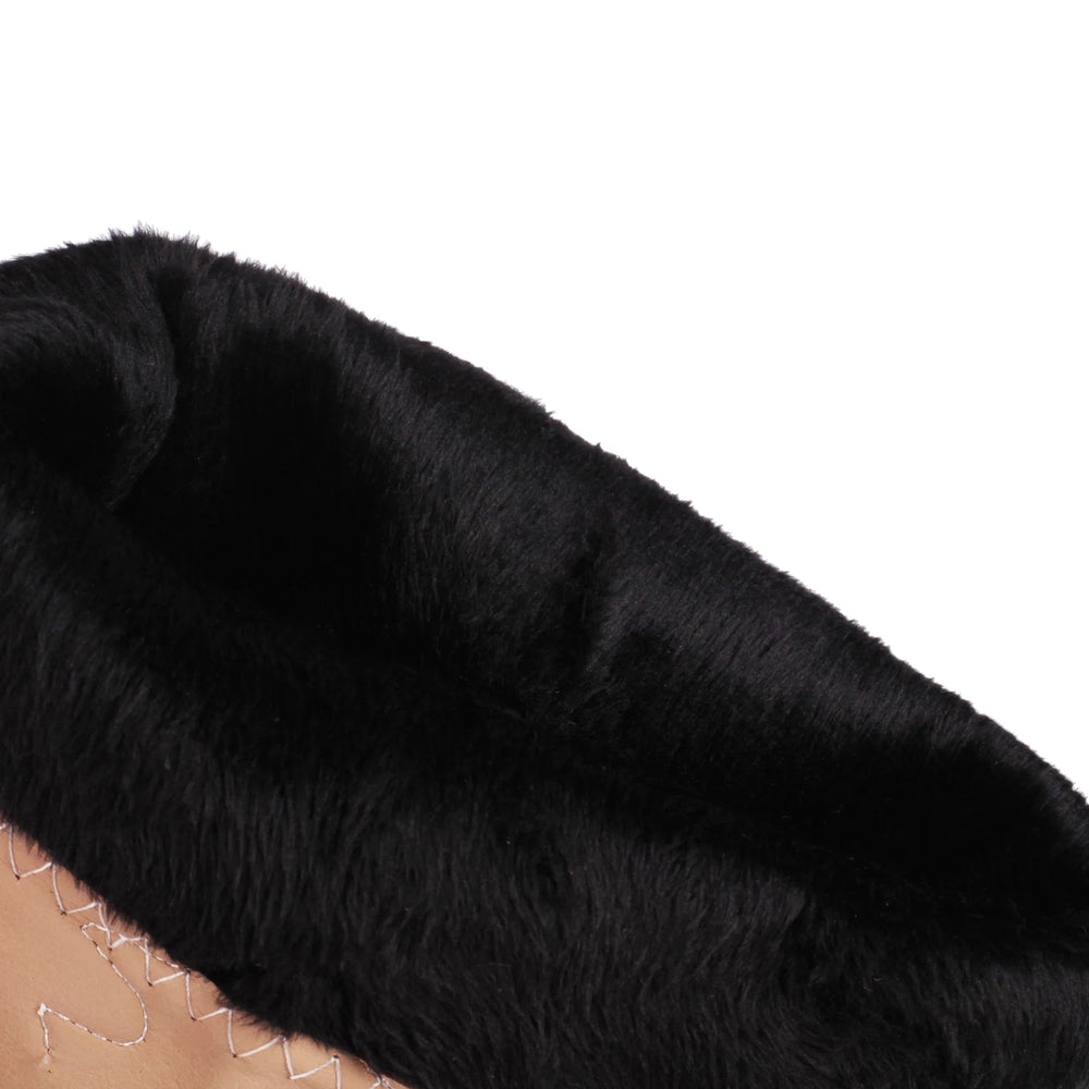 Close-up of a black fur slide boot on a white background