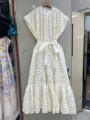 White lace dress hanging on a rack in a store setting