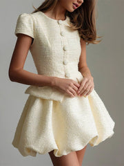 White textured dress worn by a model on a plain background