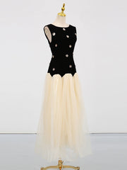 Black top with floral embellishments and beige skirt on a mannequin against a white background