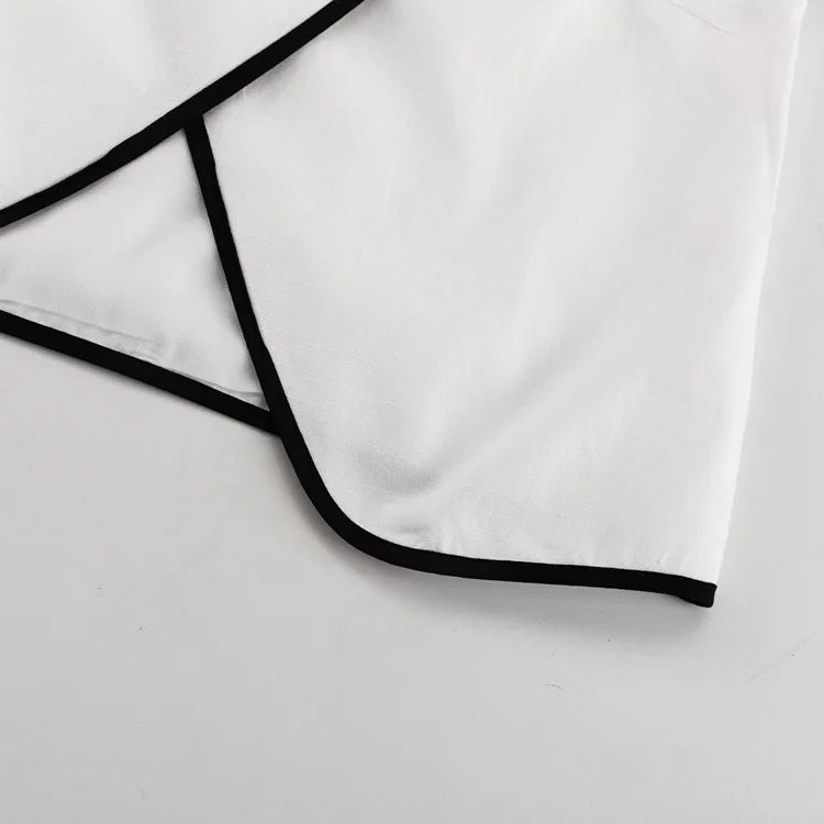 White shirt with black trim on a light gray background