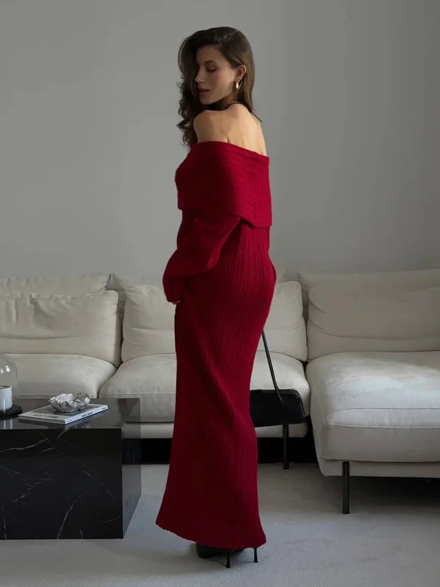 Woman in a red off-shoulder dress standing in a modern living room.