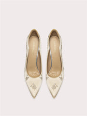 Pair of cream-colored pointed-toe shoes with floral patterns on a light gray background