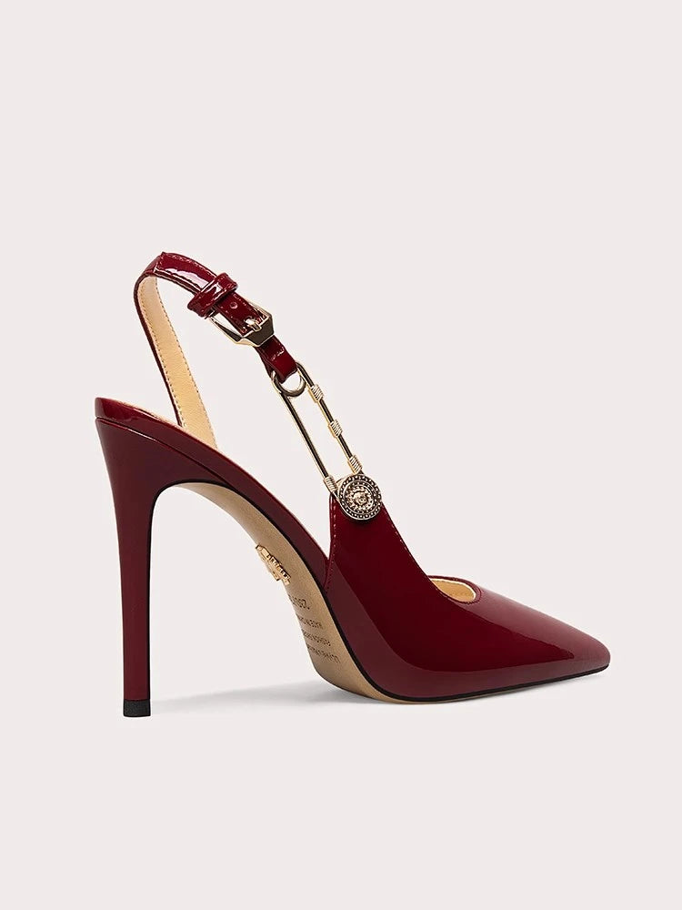Red high-heeled shoe with gold accents on a light gray background