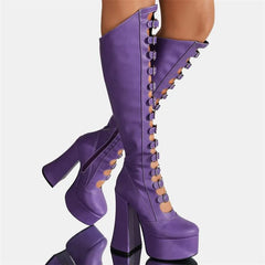 Purple platform boots with high heels on a reflective surface