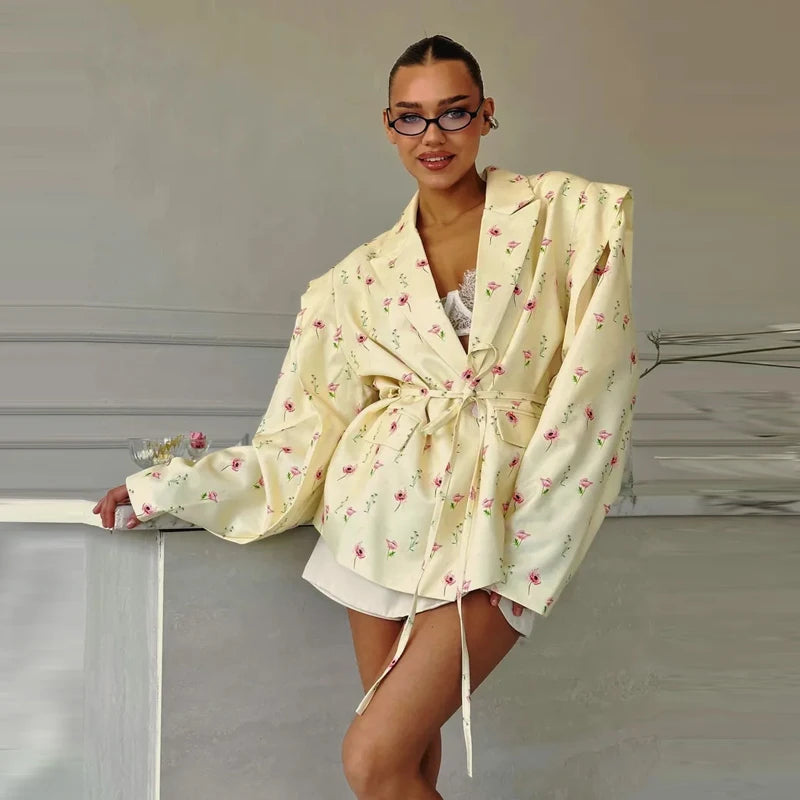 Woman wearing a cream-colored floral robe against a neutral background