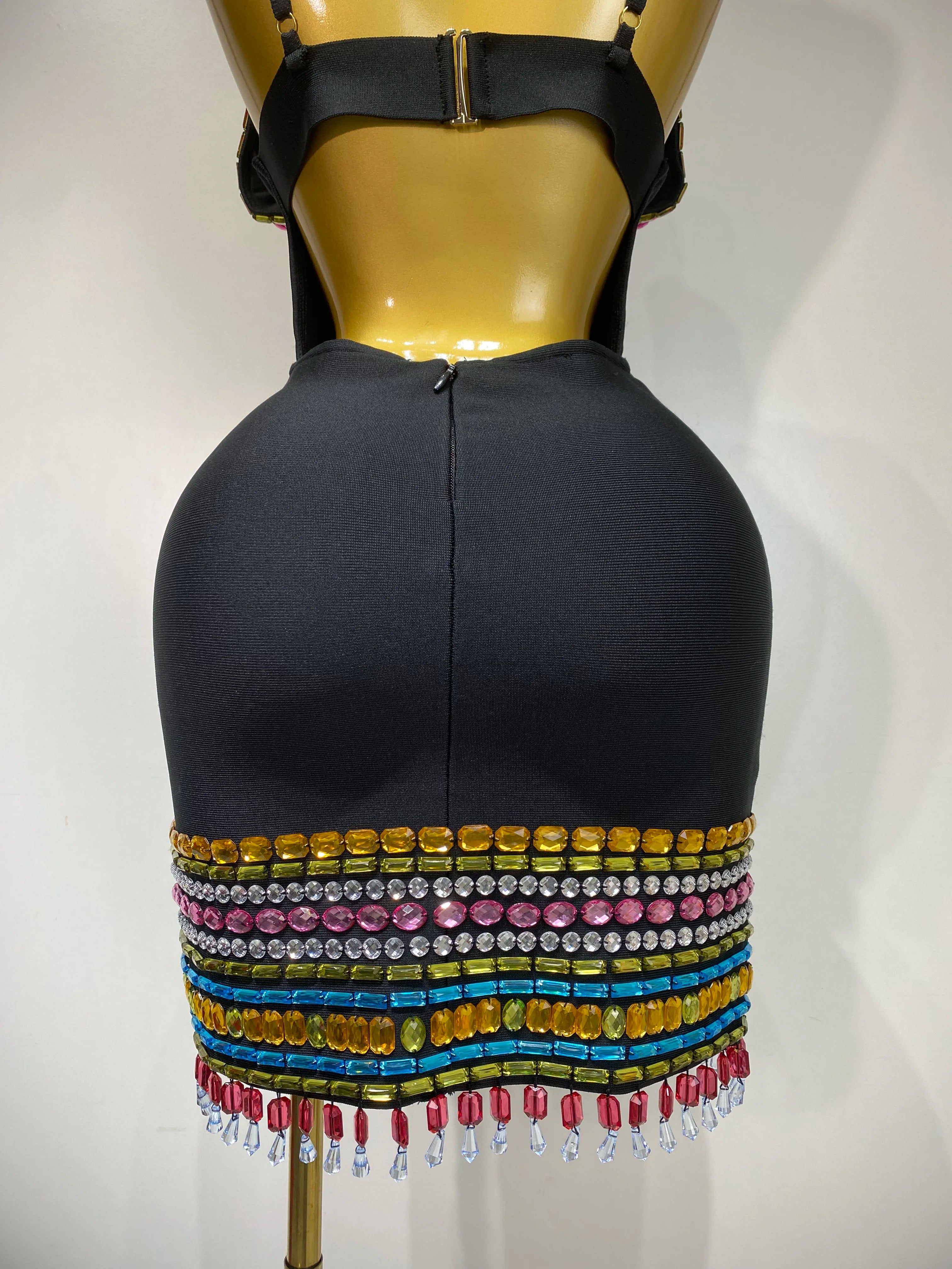 Mannequin wearing a black dress with colorful beaded fringe on a white background