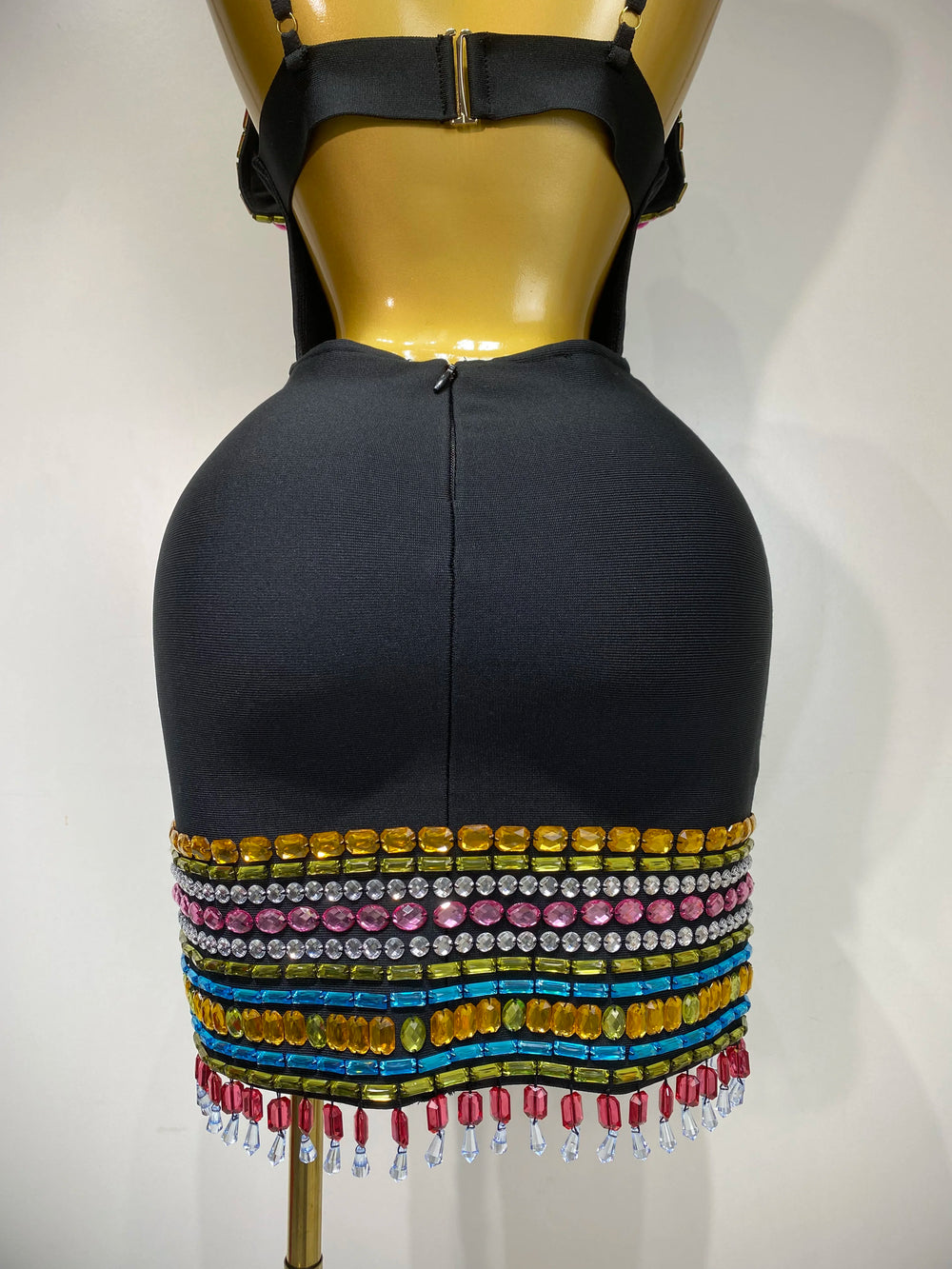 Mannequin wearing a black dress with colorful beaded fringe on a white background