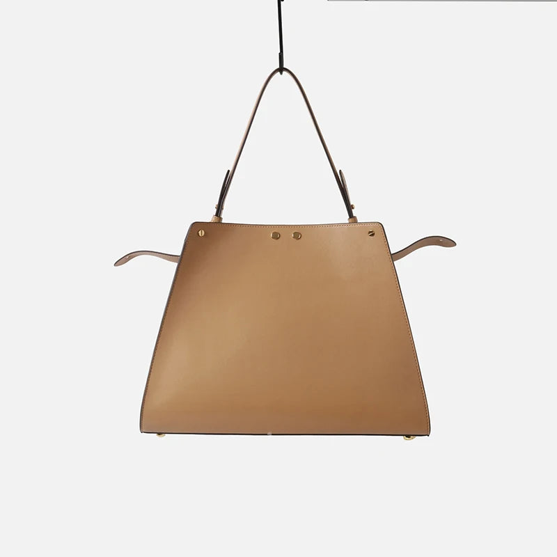Leather trapezoid top handle bag from the back.